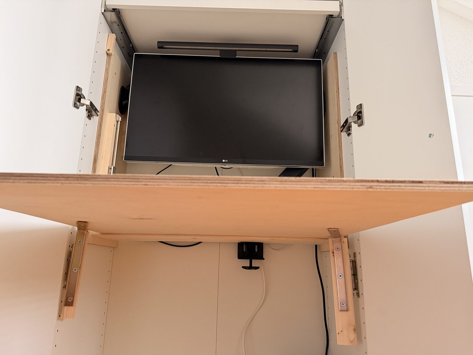 Underside view of the fold-down desk top showing the support brackets