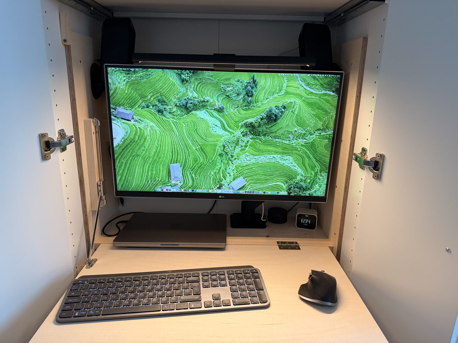 Open fold-down desk with monitor, keyboard and mouse inside the IKEA PAX