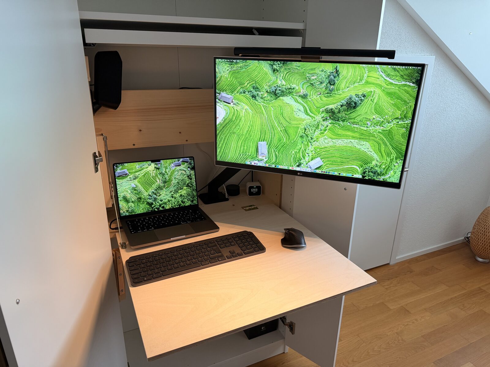 Murphy desk open with a laptop and external monitor inside the IKEA PAX wardrobe
