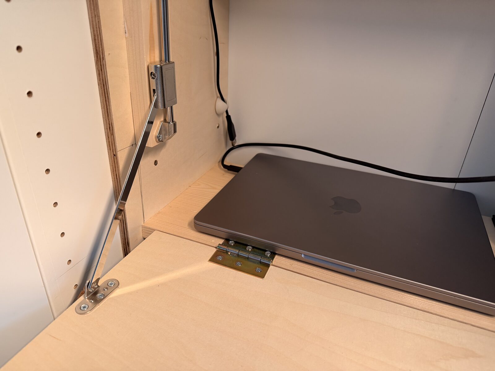 Brass butt hinge and gas-strut anchor on the fold-down desk top